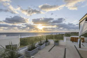 Vista del océano y el atardecer desde el balcón del hotel Azulea, creando un ambiente sereno y pintoresco.